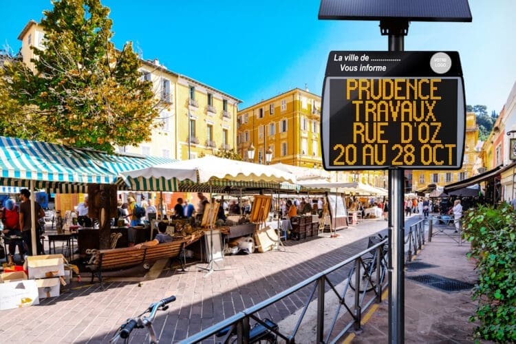 Le journal d'information électronique EVOCITY équipé d'un panneau solaire, installé près d'un marché.