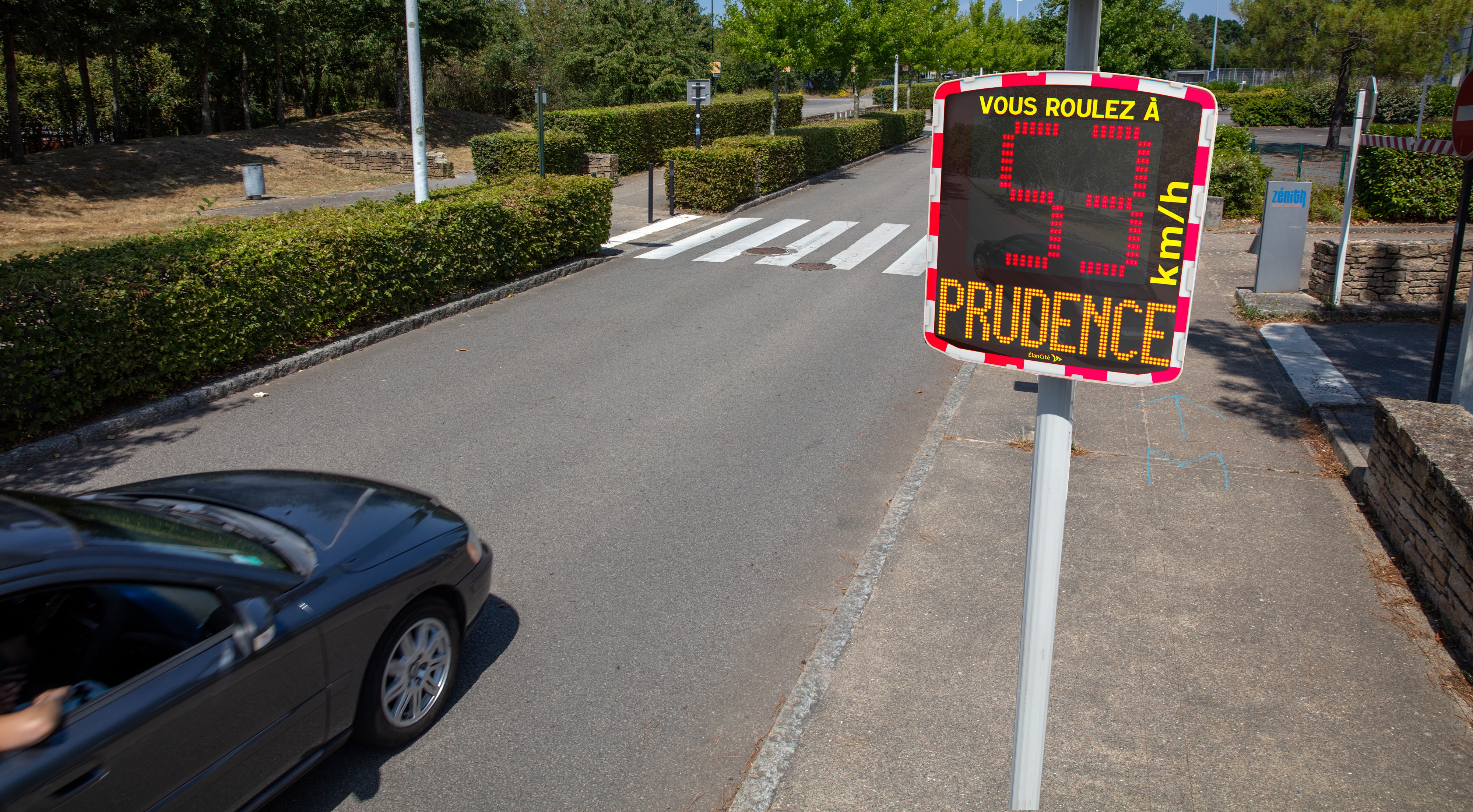 Un radar pédagogique mobile installé aux abords d'une rue communale et qui affiche une allure de vitesse excessive de 53km/h et un message de prévention PRUDENCE