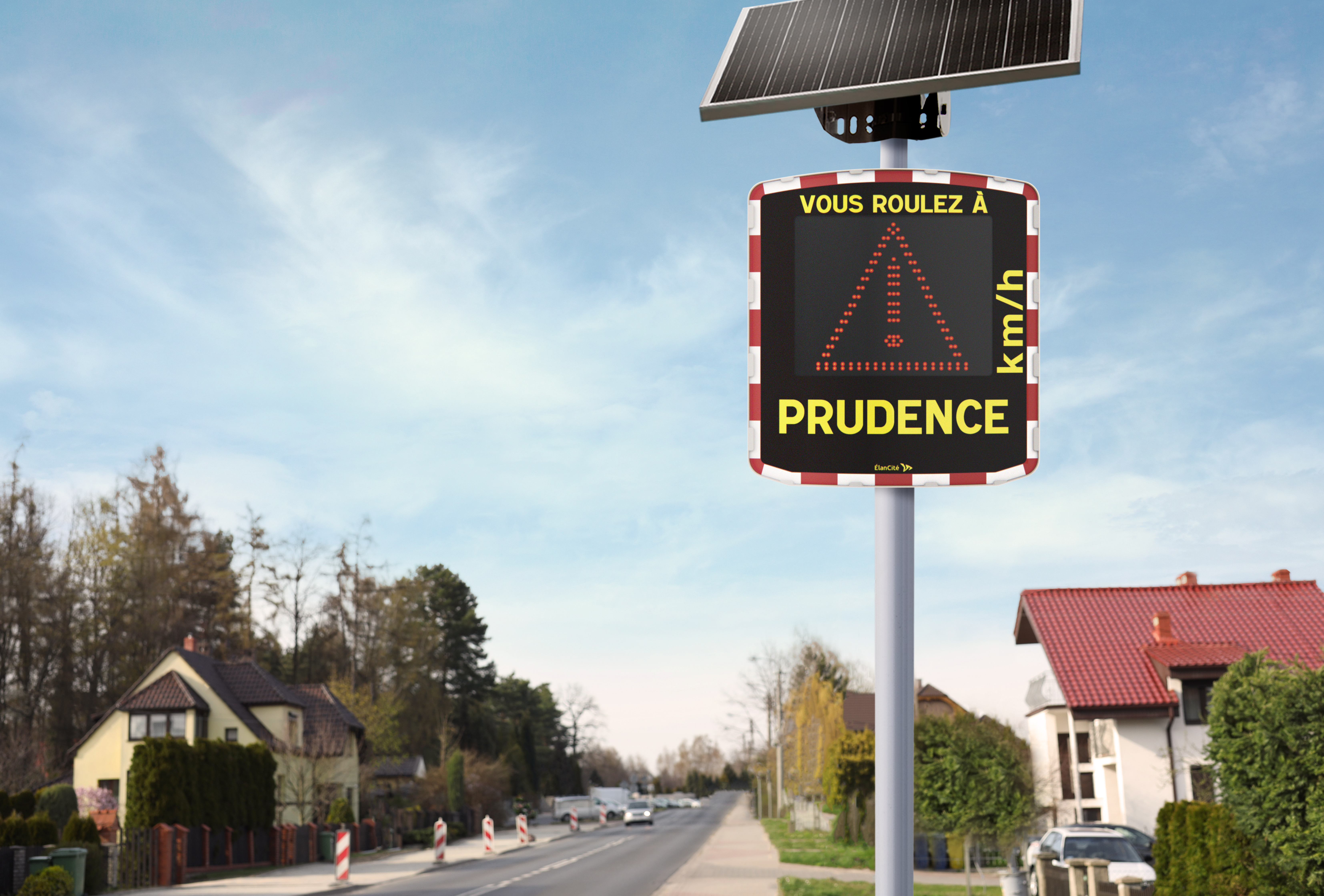 Un radar pédagogique mobile installé aux abords d'une rue pavillonnaire et qui affiche un triangle danger.