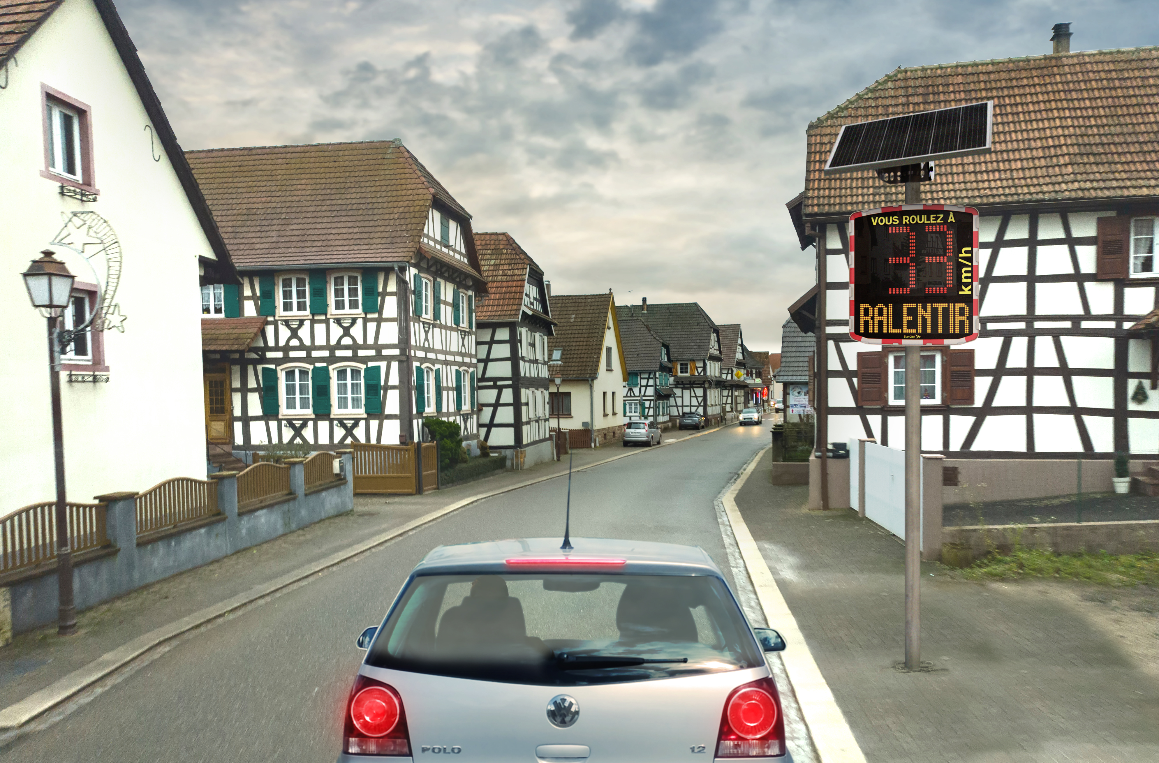 Un radar pédagogique solaire installé dans une rue communale en Alsace et qui affiche une allure de vitesse excessive de 33km/h et d'un message de prévention "RALENTIR"