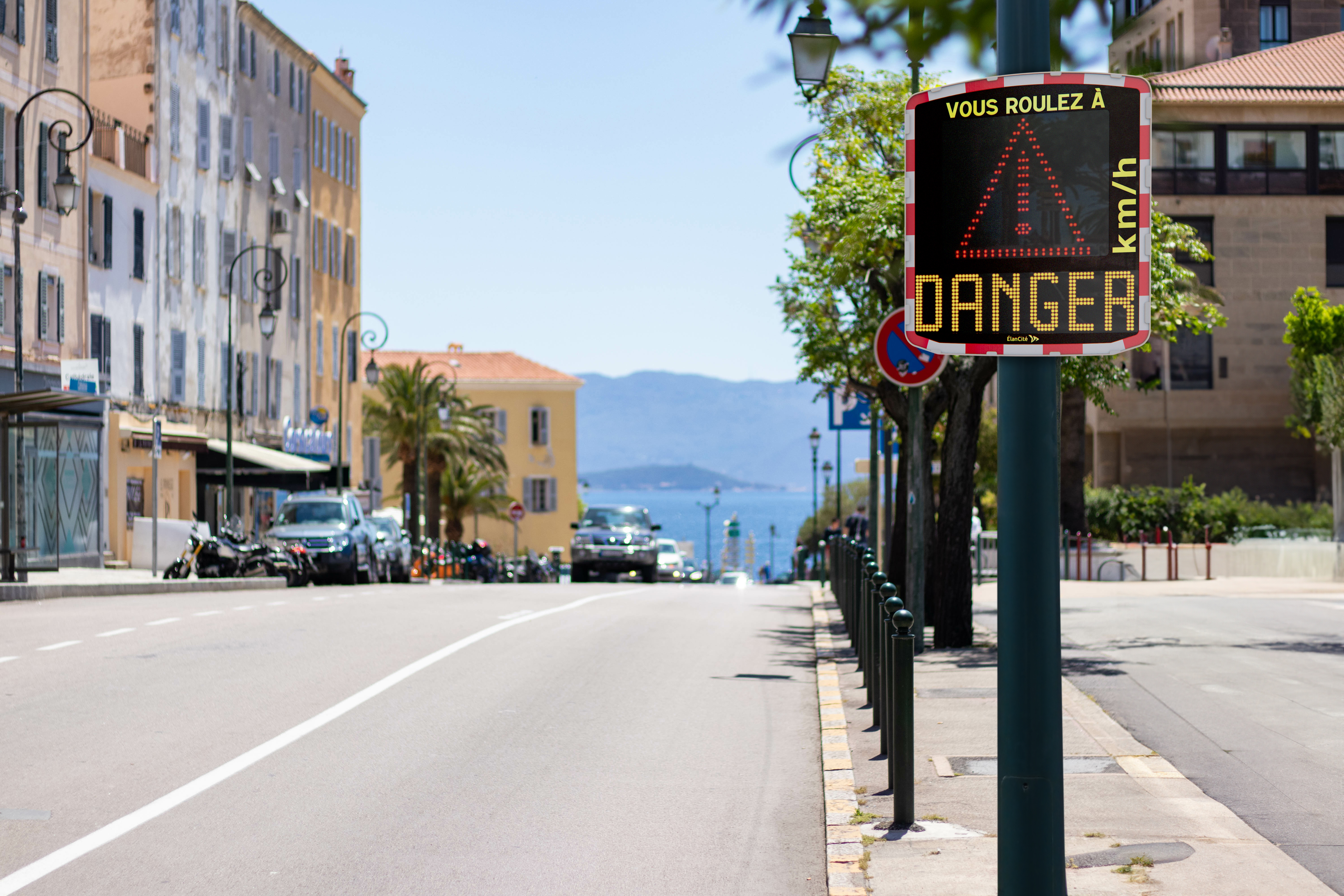 Photomontage d'un radar pédagogique installé aux abords d'une rue urbaine et qui affiche un triangle et un message de prévention "DANGER"